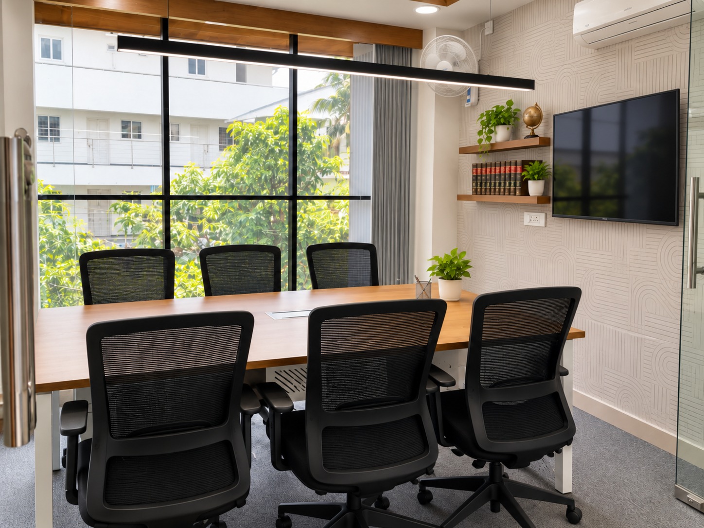The My Office conference room with a wall-mounted display and natural light